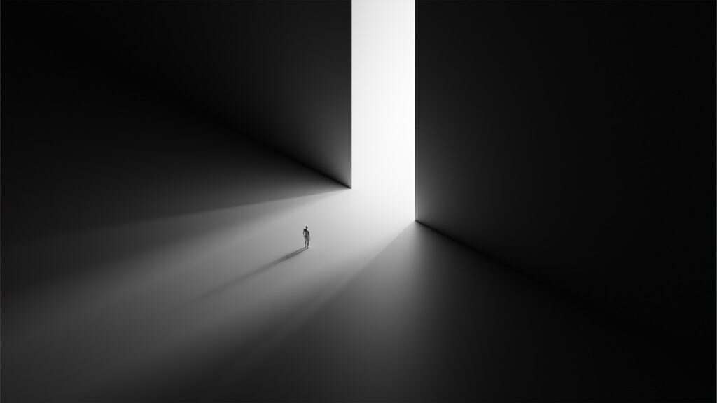 a person standing in a dark room with a light at the end of the room