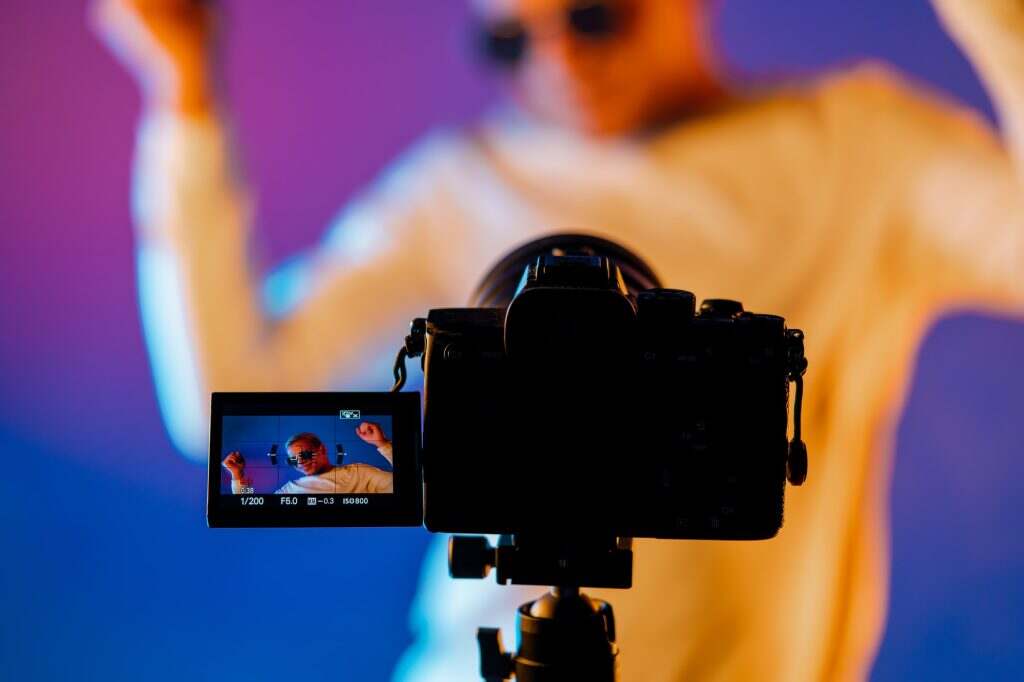 Backstage how operator working with professional. Videographer shoots music clip with actor singer