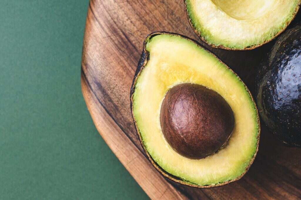Half of Avocado Hass on Wooden Board.