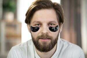 Caucasian man with black patches under eyes from wrinkles and dark circles