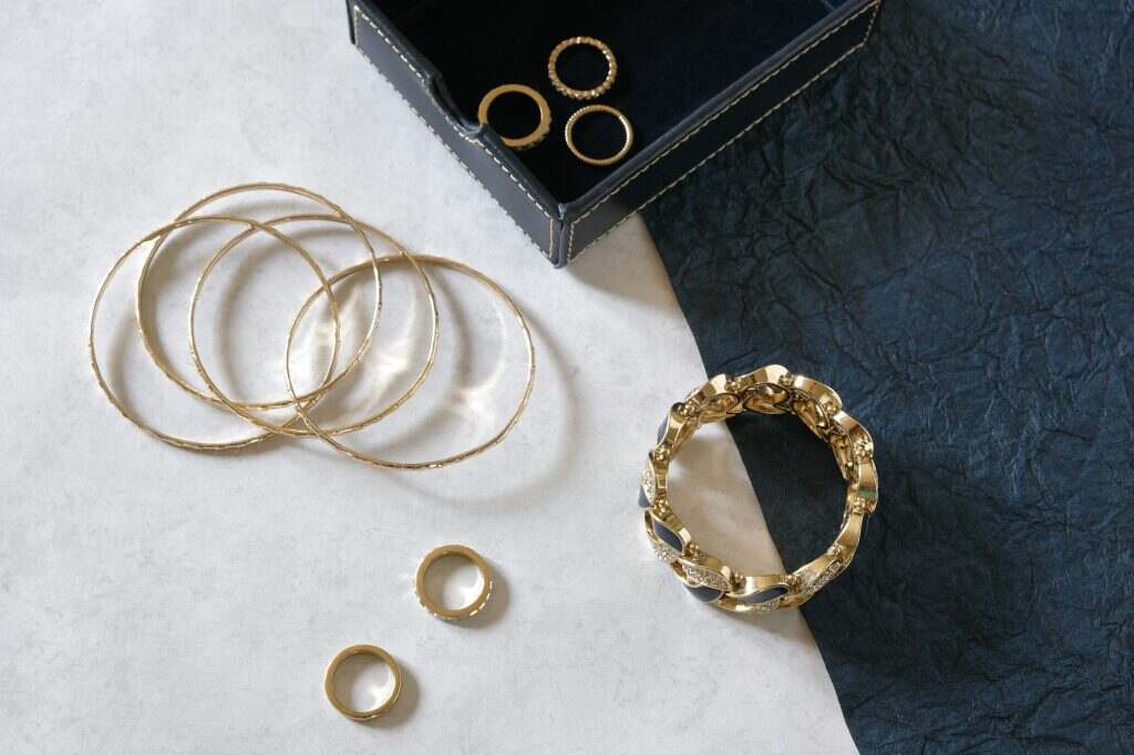 Gold jewelry flat lay on two toned light and dark background