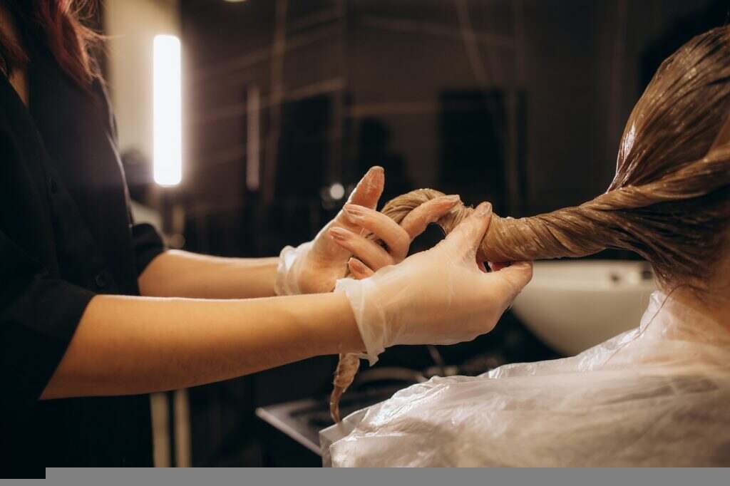 Éclaircir ses cheveux : tout ce qu’il faut savoir Hair coloring in the salon, hair styling. Professional wizard paints the hair in the salon.