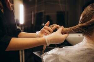 Hair coloring in the salon, hair styling. Professional wizard paints the hair in the salon.