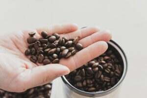 Hand full of coffee beans before grinding.