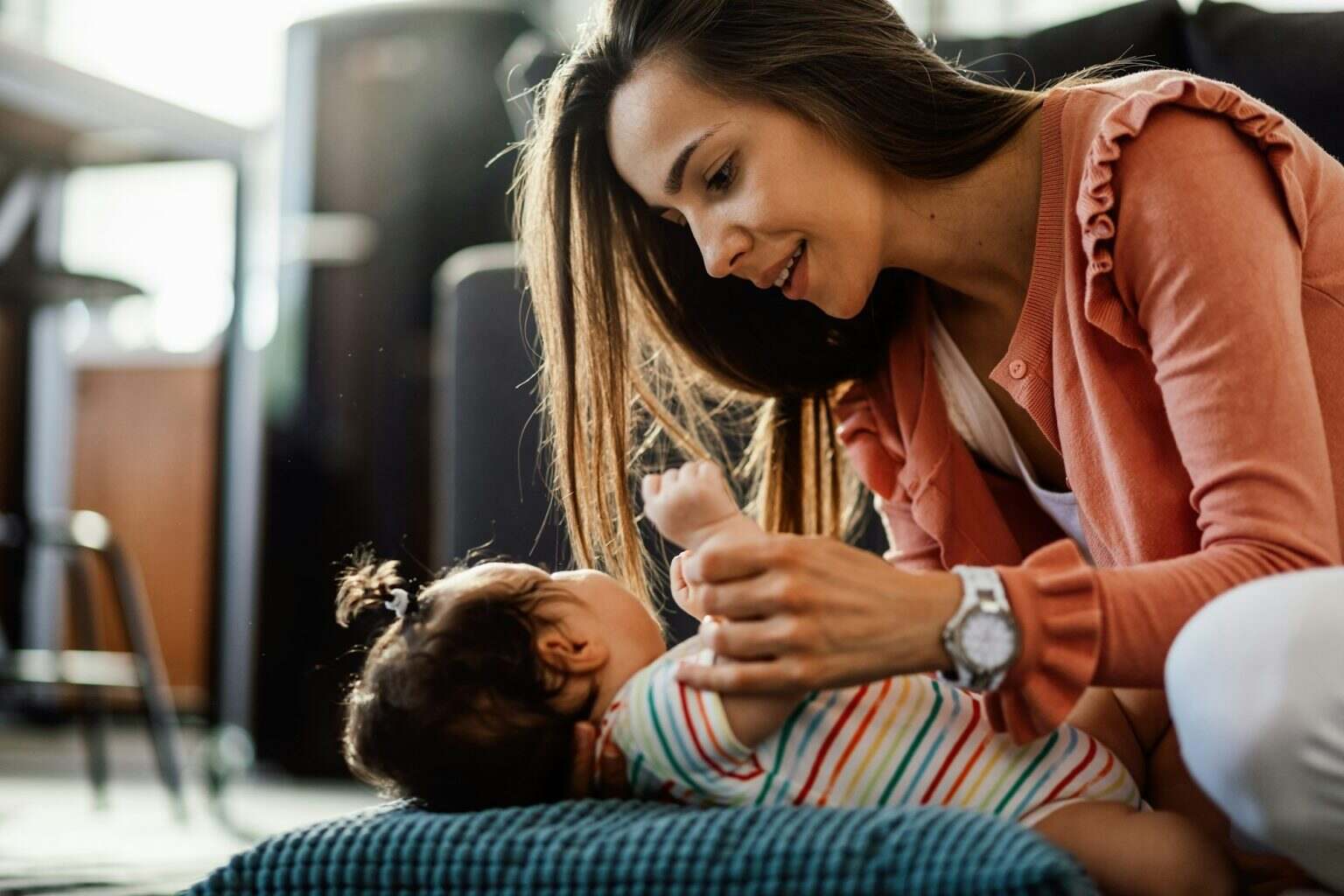 Young mother with her baby girl at home.