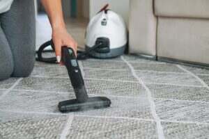 Woman cleaning carpet with a steam cleaner