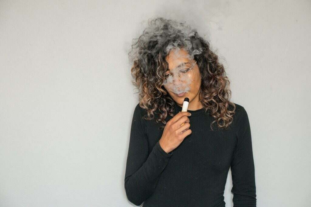 Woman smoking a e-cigarette shot up close
