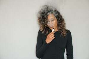 Woman smoking a e-cigarette shot up close