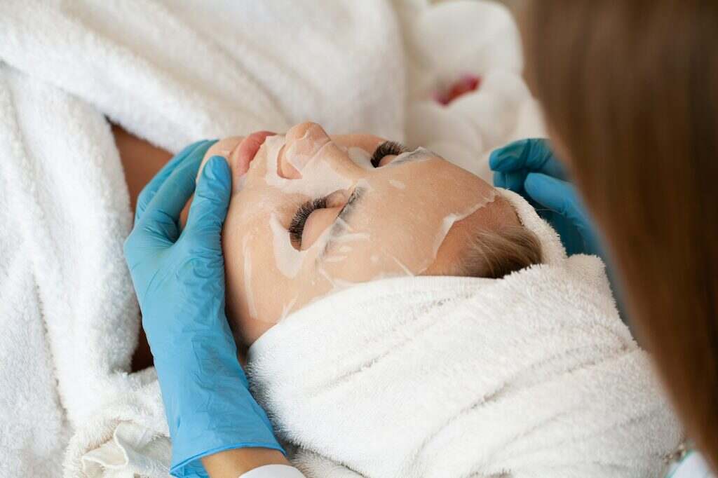 Young woman on a look after face and mask against black dots
