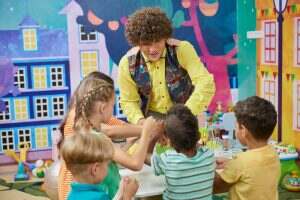 Animator with happy children indoor.