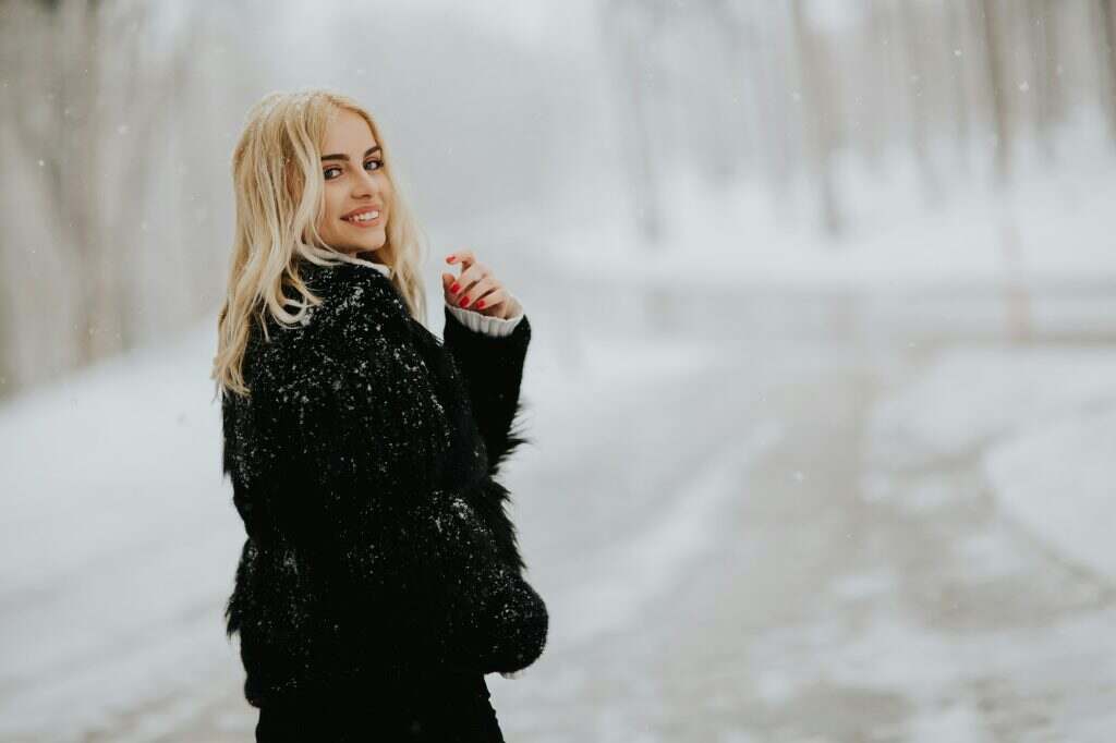 Blonde woman outside in snow winter coat