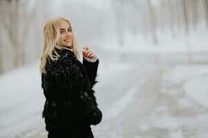 Blonde woman outside in snow winter coat