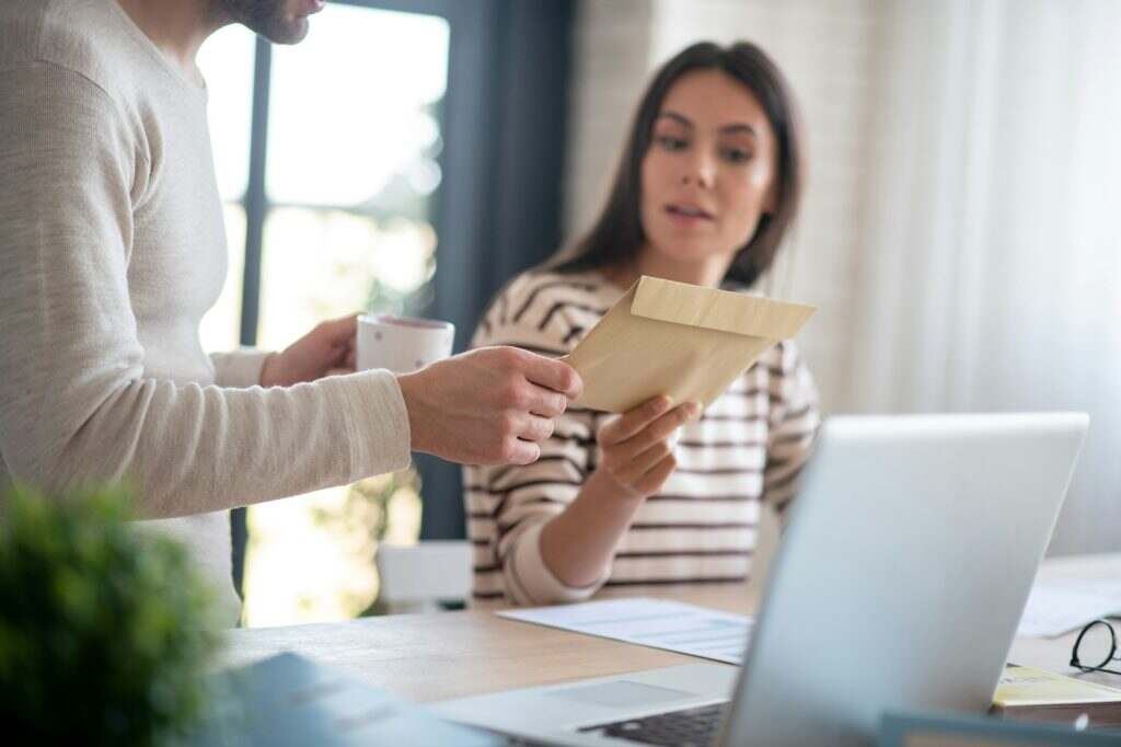 Close up of wife giving letter to husband after going to post