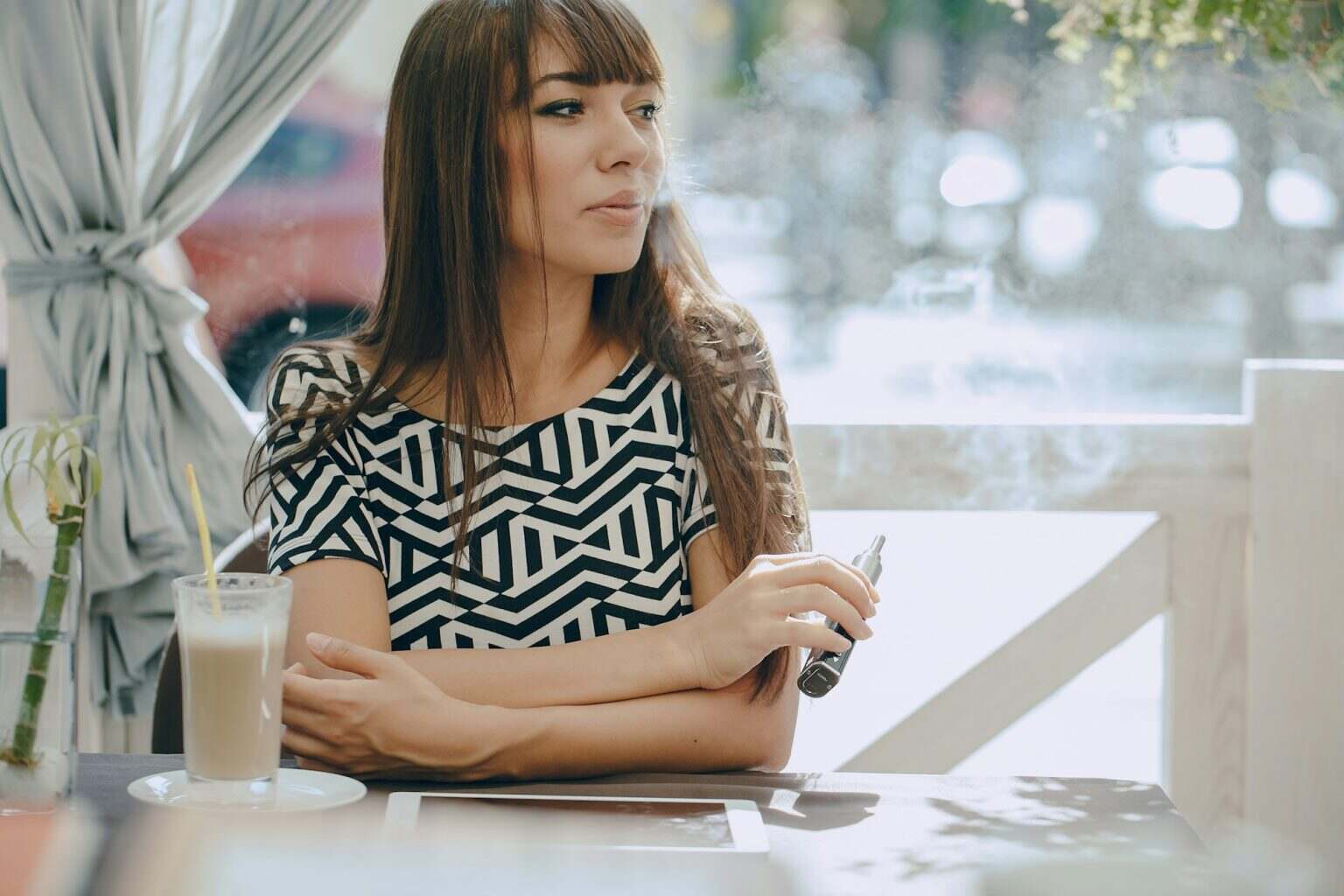 girn in cafe with E-Cigarette