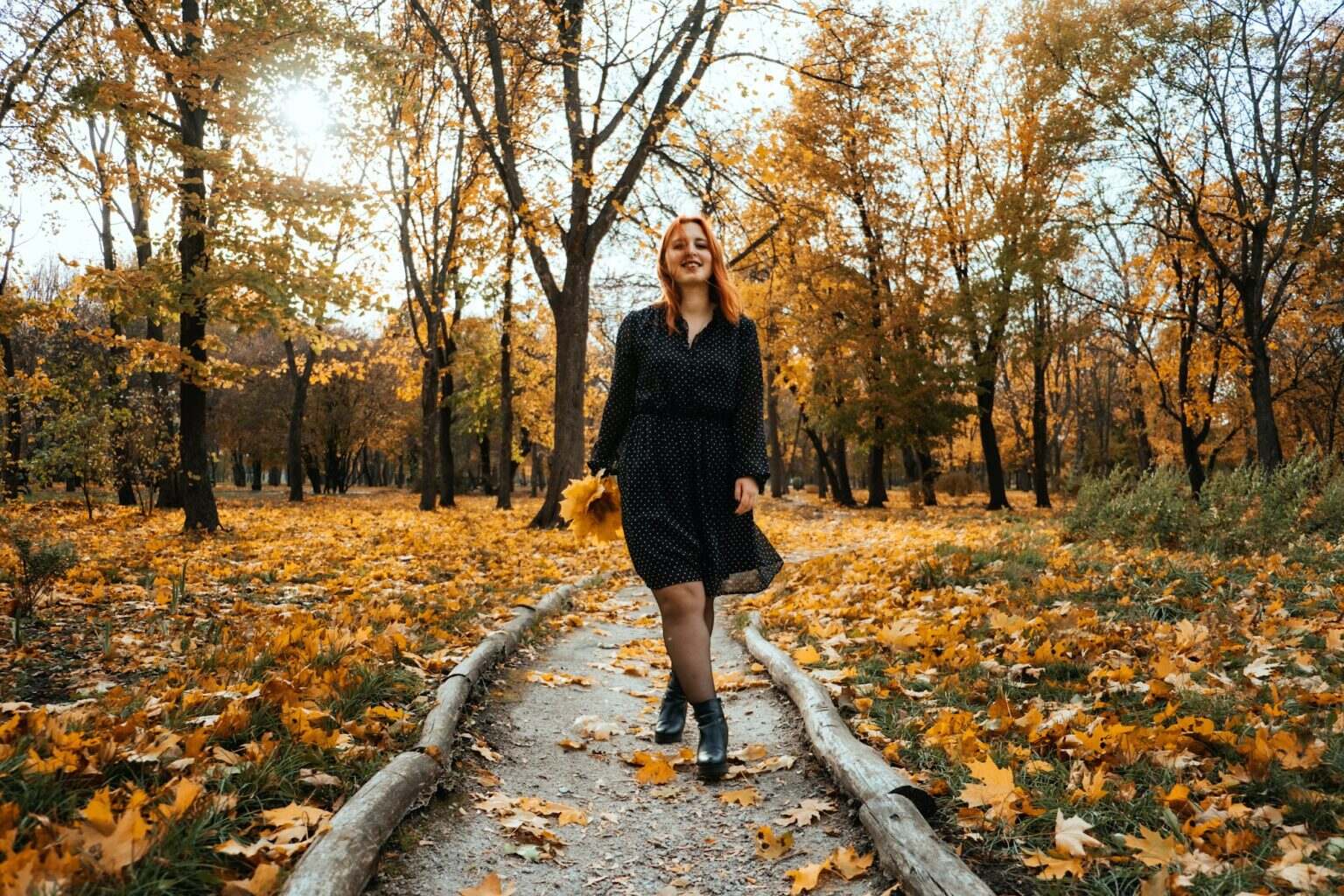 Outdoor autumn portrait of happy smiling plus size red hair woman in dress