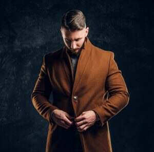 Portrait of a stylish male wearing the demi-season coat. Men's beauty, seasonal fashion