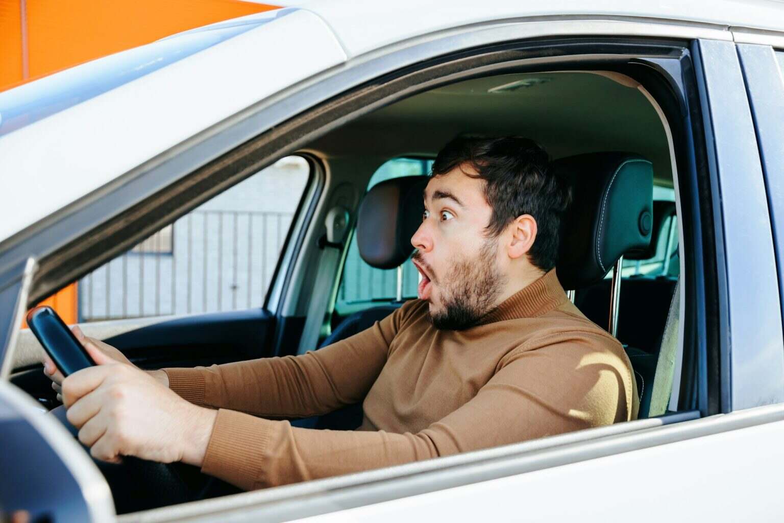 Sincere surprise and joy is experienced by a young guy behind the wheel.