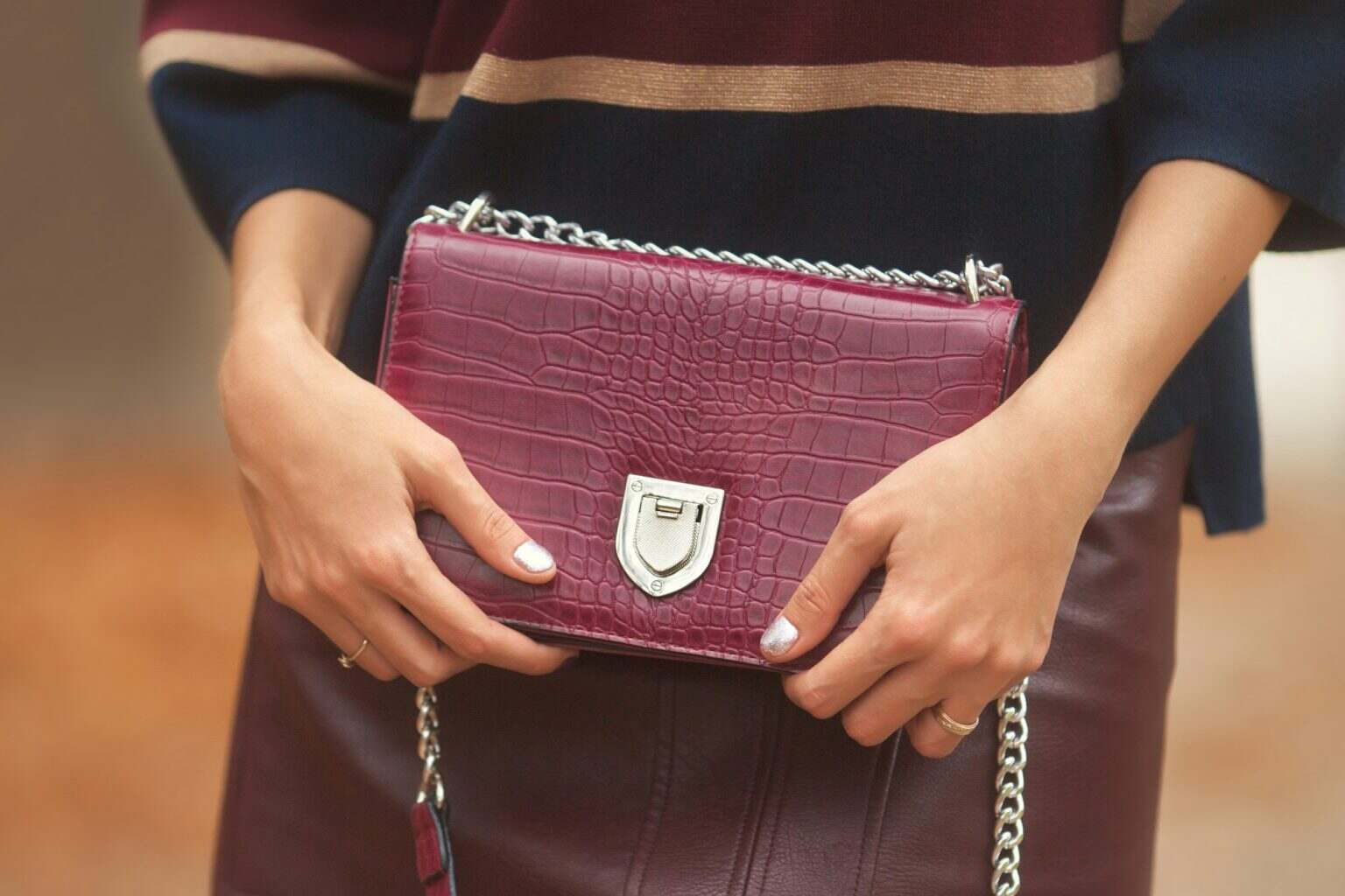Womans hands holding fashion bag in stylish clothes