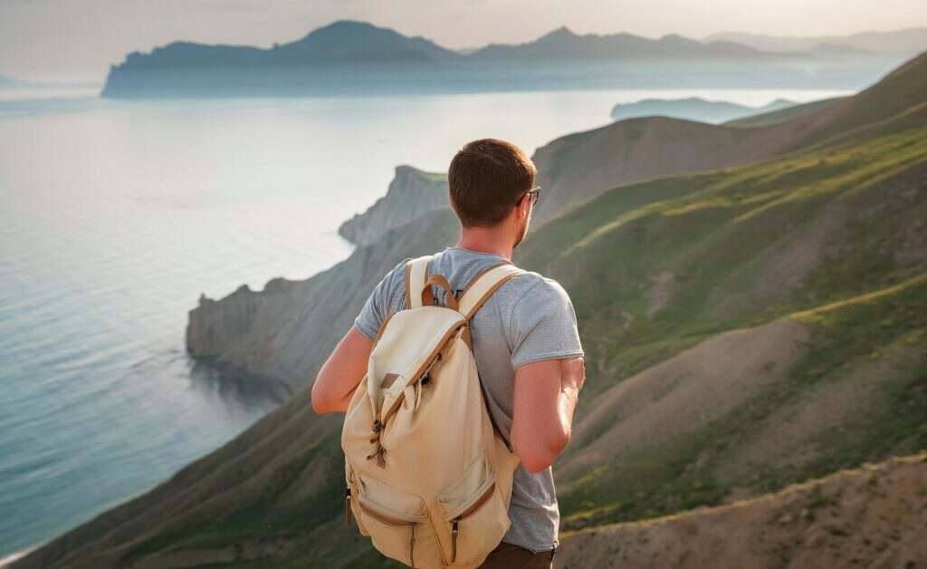 Young man travels alone on the backdrop of the mountains