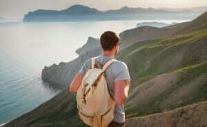 Young man travels alone on the backdrop of the mountains