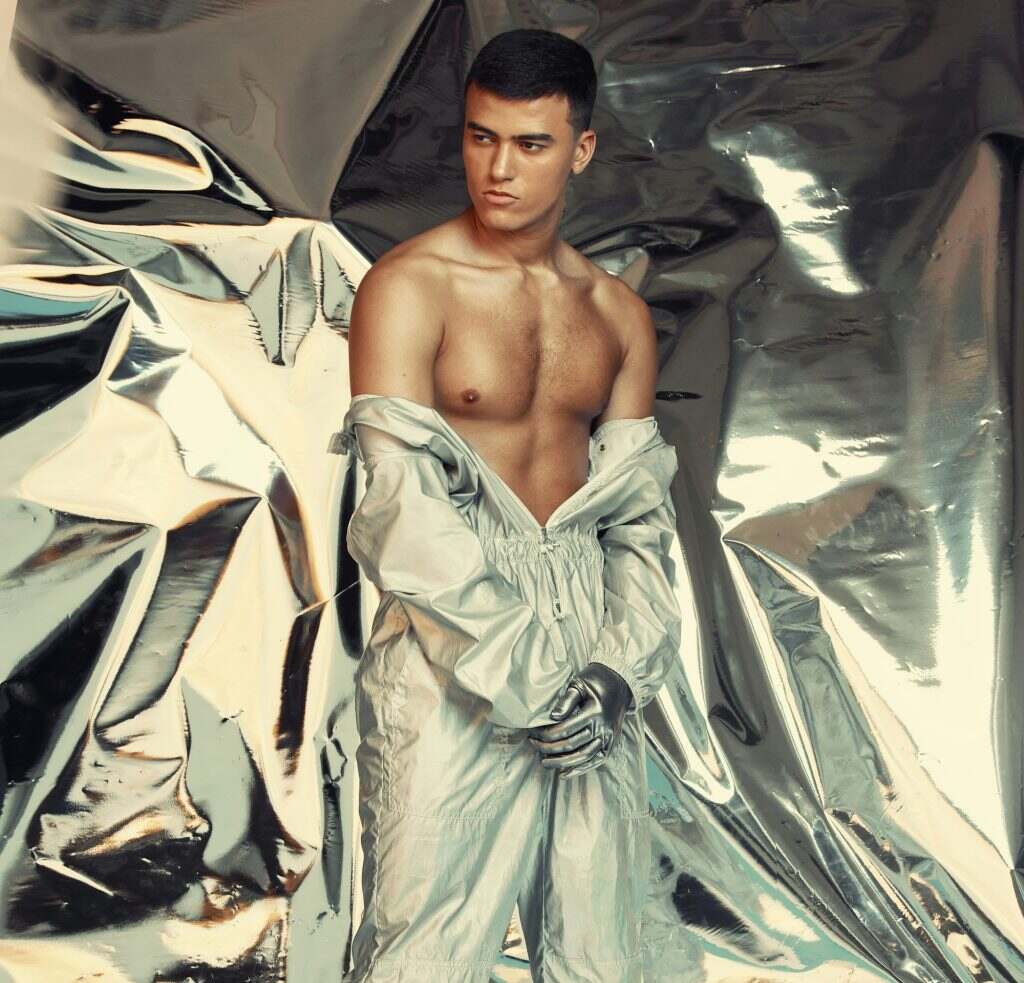 Fashion, sci fi and silver with a trendy man at a photo shoot in a shiny outfit for futuristic styl