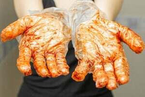Hands in gloves stain with dye