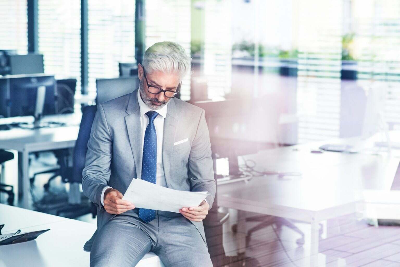 Mature businessman in gray suit in the office.