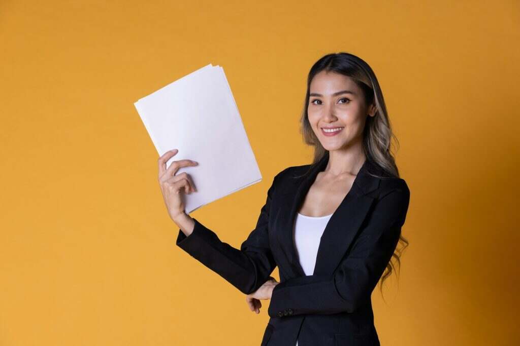 Portrait of business woman smiling with reports paper on hand