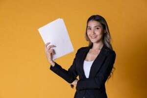Portrait of business woman smiling with reports paper on hand