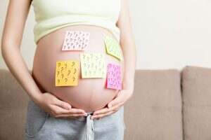Pregnant woman belly with question mark. Pregnancy and thinking problem