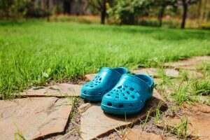 rubber sandals stand on the garden path near the lawn grass