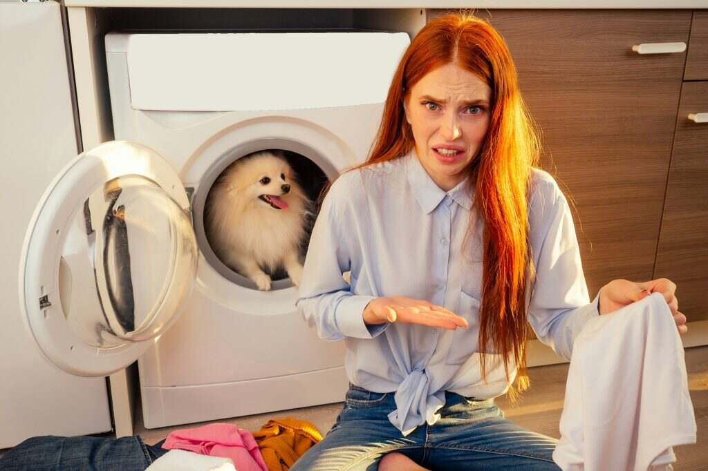 Comment enlever l’odeur de gasoil sur les vêtements ? Techniques efficaces et conseils pratiques Shocked funny redhaired girl wash pile of dirty smelly clothes