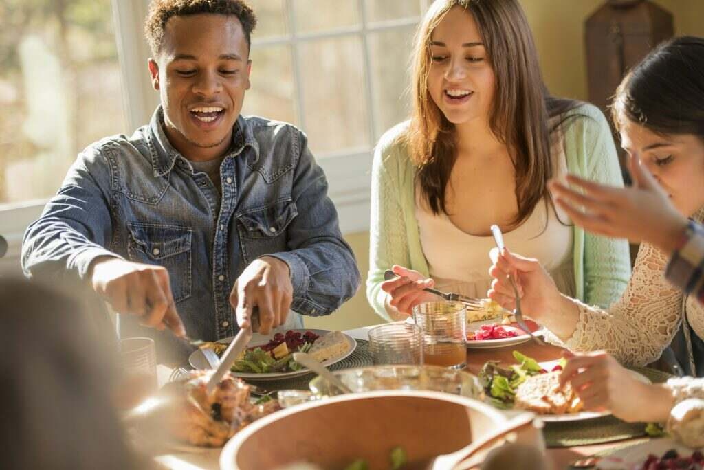 A group of people, adults and children, seated around a table for a meal.