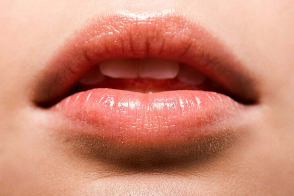 close up of woman with shiny lip gloss on lips