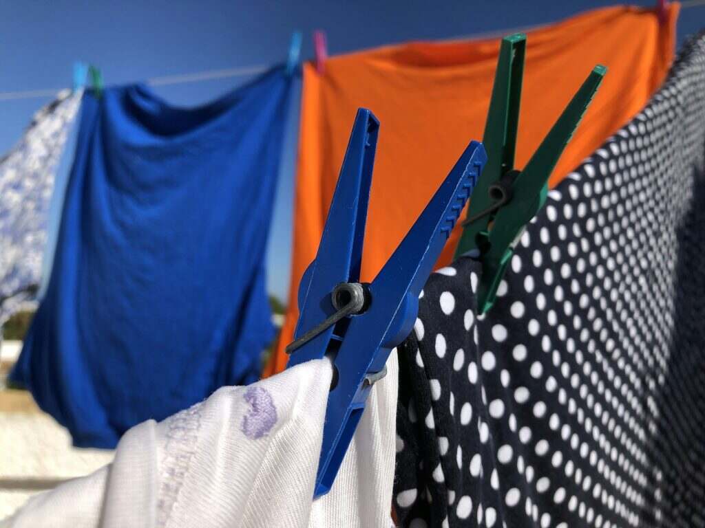 Tache de Transpiration : Comment Enlever les Marques de Sueur Clothes hanging out to dry on washing line outdoors in the sun.