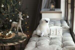 Decorated home room with interior calendar date December 25 and christmas tree with light garland