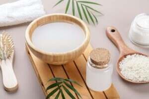 Homemade cosmetic rice water with ingredients on beige background