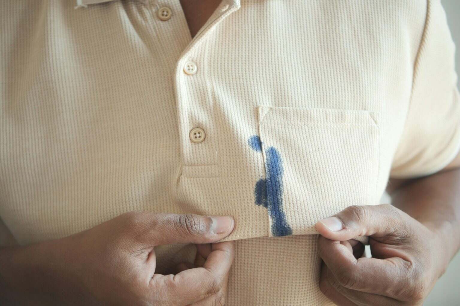 men wearing orange shirt with blue ink stain .
