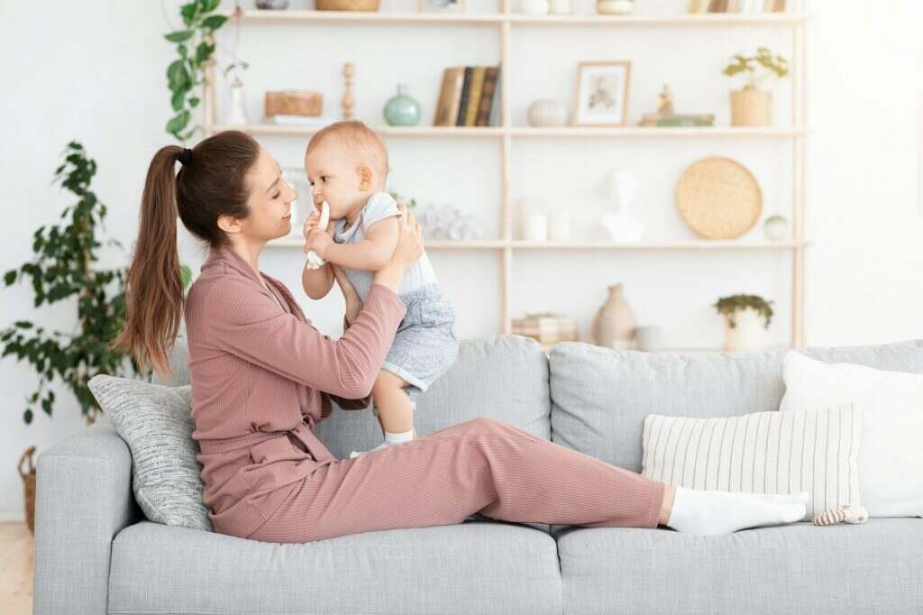 Mother-baby emotional attachment. Young Mom bonding with adorable toddler baby at home