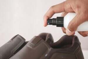 spraying deodorant on sweaty shoes.