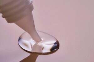 Stationery glue flows onto pink paper.