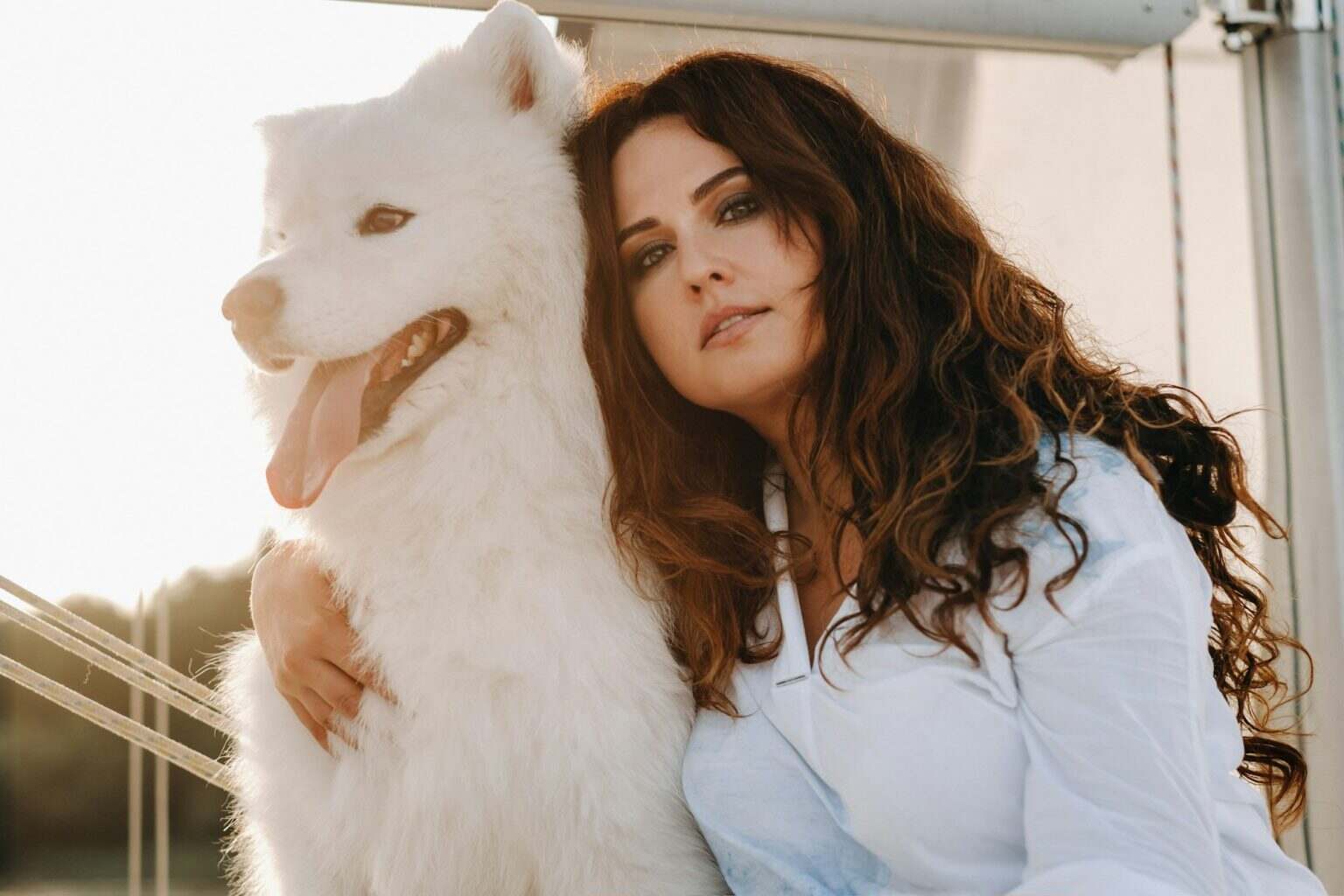 Les mensurations des mannequins grande taille : au-delà des clichés a happy woman with a big white dog on a white yacht in the sea