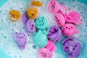 Dirty socks soaked in water, dissolving detergent in basin.