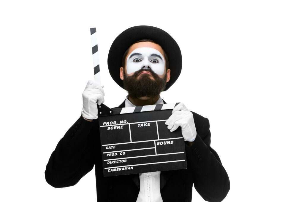 man in the image mime with movie board