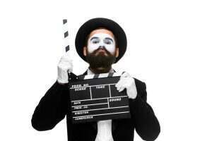 man in the image mime with movie board