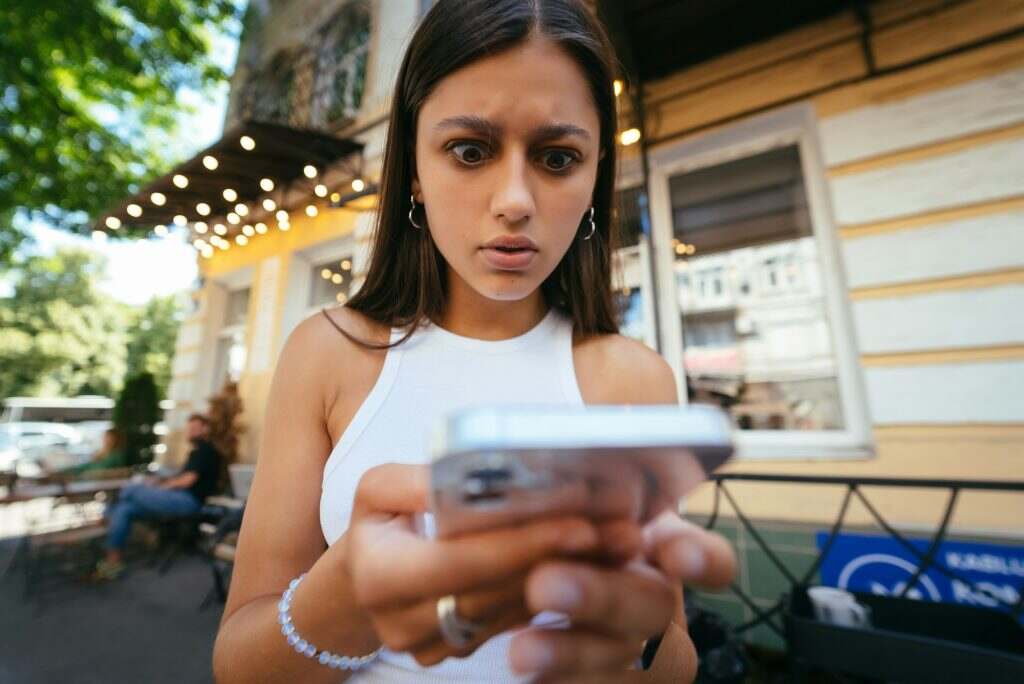 Pretty woman an urban street to read an sms on her mobile phone