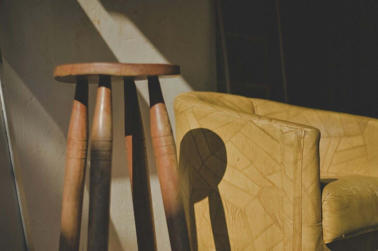 Le tabouret Tam Tam, une icône du design français 🇫🇷 brown wooden stool near barrel chair