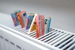 euro banknotes in a central heating radiator, the concept of expensive heating costs, closeup