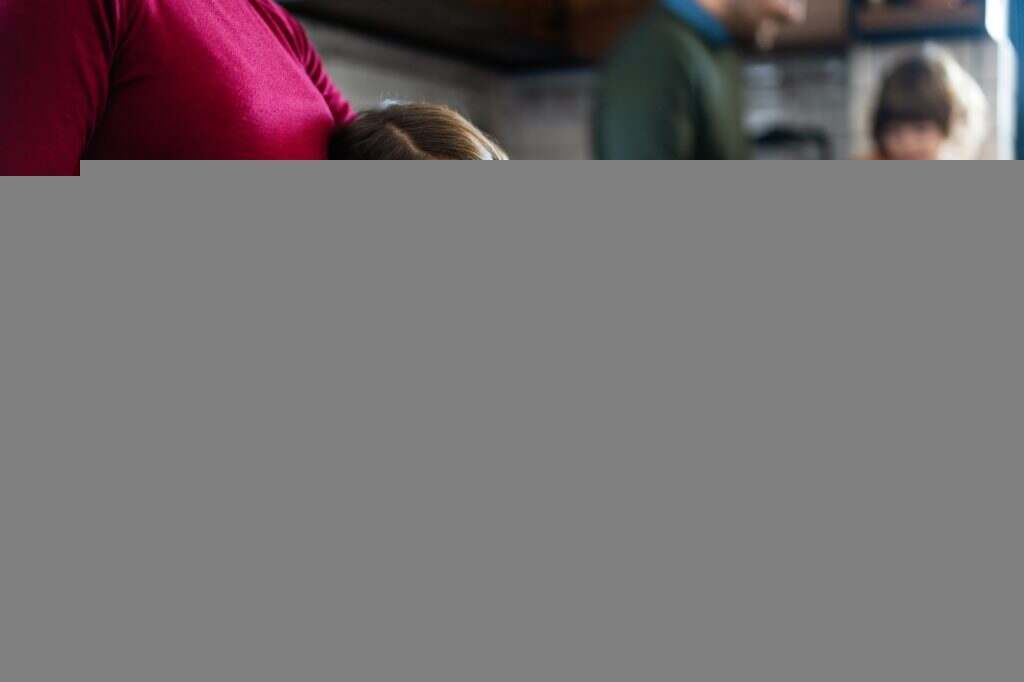 Lovely daughter touching mother's pregnant belly. Happy little girl feeling baby at mother tummy