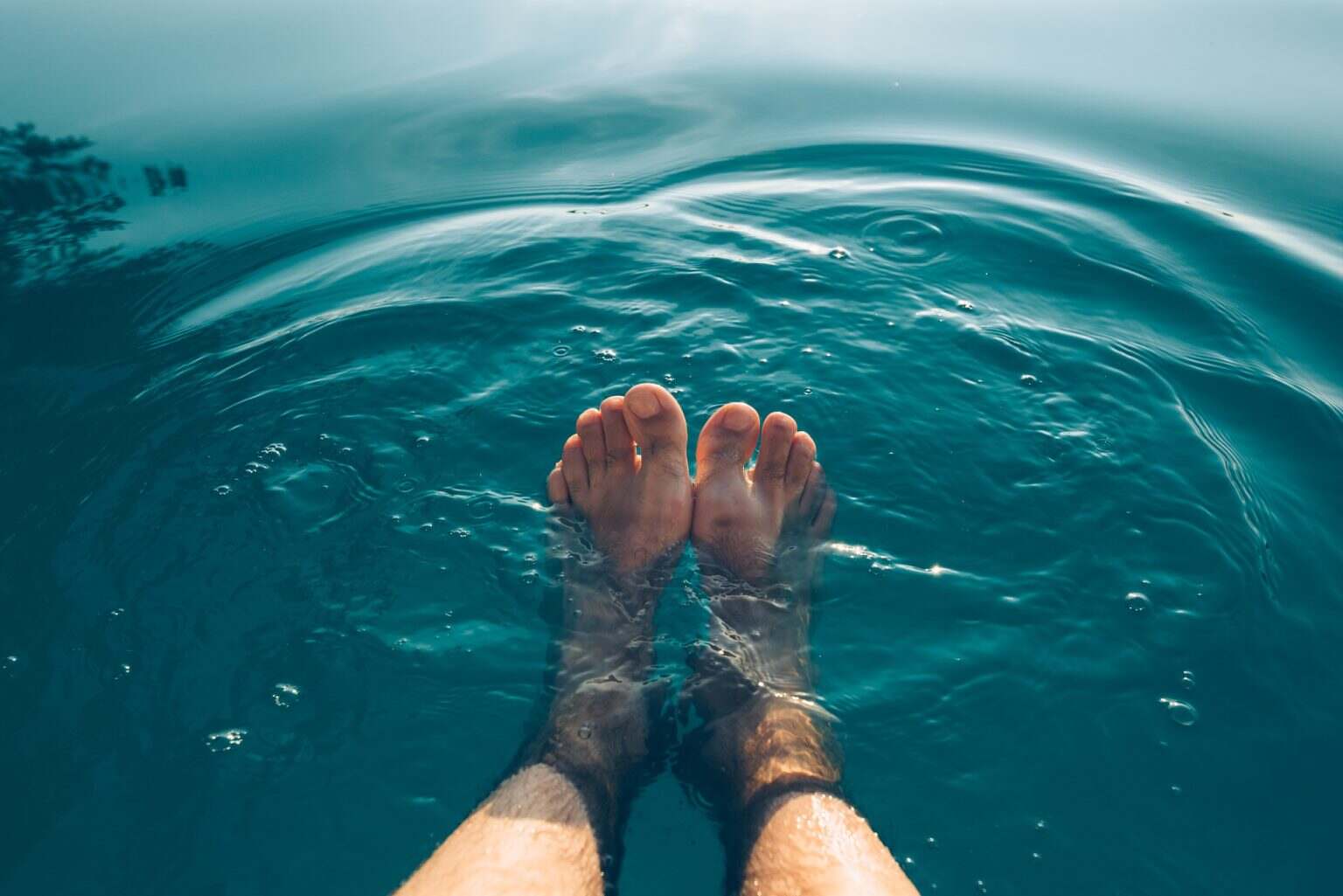 4 conseils pour relooker votre piscine hors-sol Male feet in outdoor swimming pool